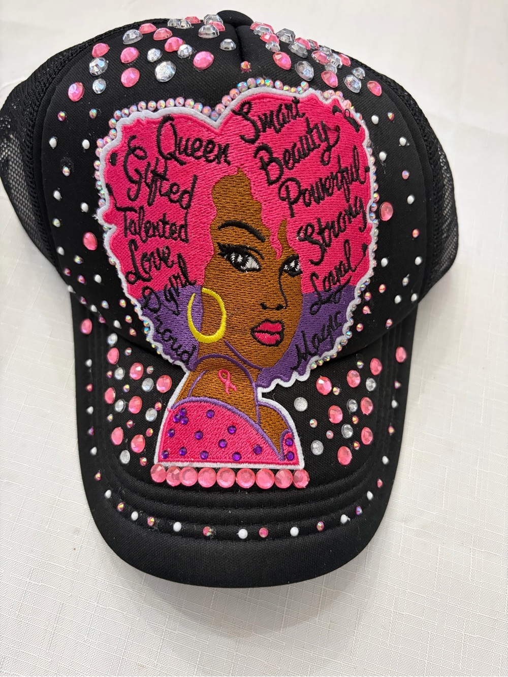 Womenโs Black Trucker Hat with Pink Embroidered Afro Design